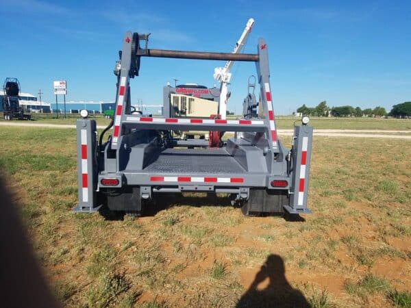 A large truck parked in the grass near some trees.