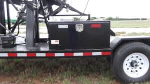 A black truck with a red and white stripe on the side.