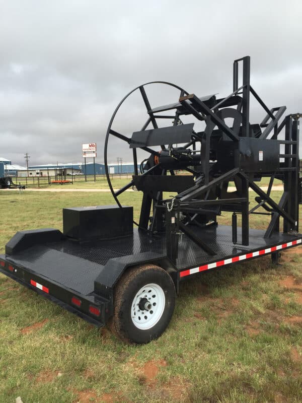 A large black machine sitting on top of a field.