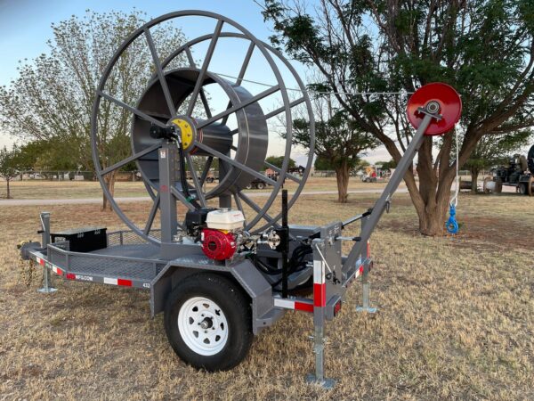 A large metal hose reel attached to the back of a trailer.