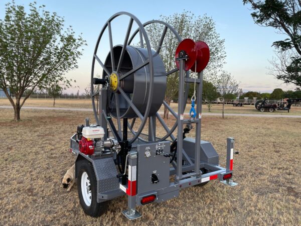 A large hose reel attached to the back of a trailer.