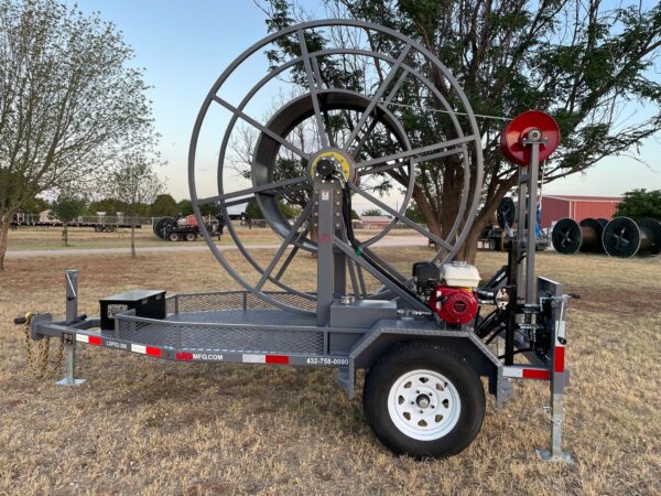 A large metal hose reel attached to the back of a trailer.