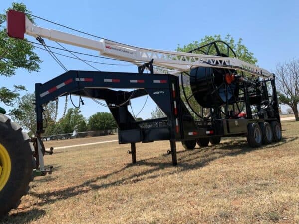 A large crane truck parked in the middle of a field.