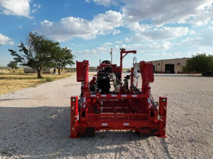 A red tractor parked on top of a gravel road.