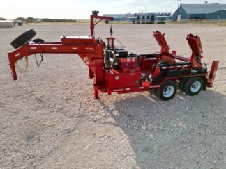 A red log splitter sitting on top of a dirt field.