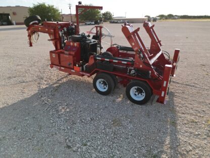 A red trailer with a large machine on it.