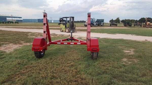 A red trailer with two large wheels on it