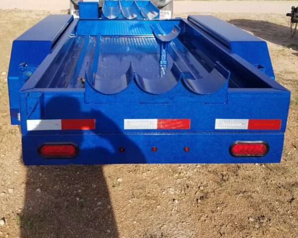 A blue trailer with red and white stripes on it.