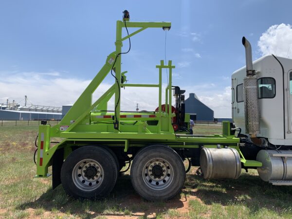 A green truck with a crane on the back.