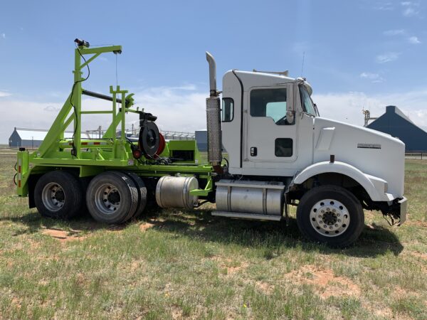 A white and green truck parked in the grass.