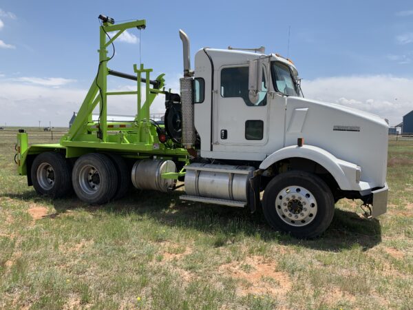 A white truck with green trailer on the back