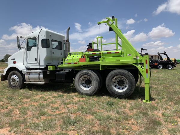 A large green truck parked in the grass.