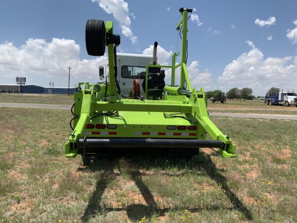 A green tractor is parked in the grass.