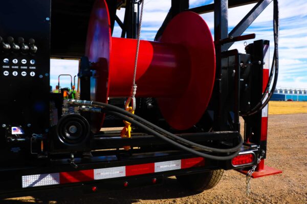 A red cable reel on the back of a truck.