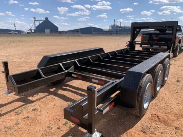 A black trailer with metal frame on the ground.