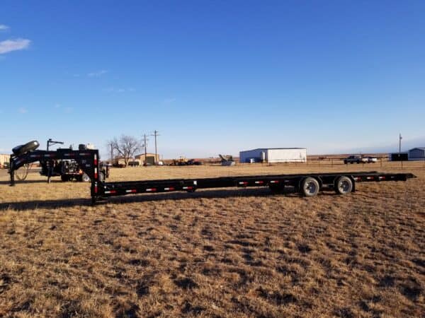 A truck is parked in the middle of an empty field.