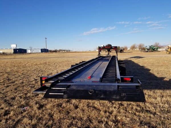 A large black trailer in the middle of nowhere.