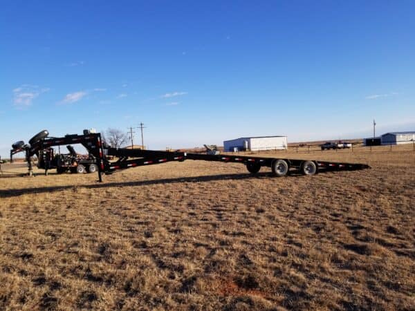 A large trailer is parked in the middle of an empty field.