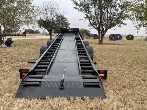 A large trailer is parked in the grass.