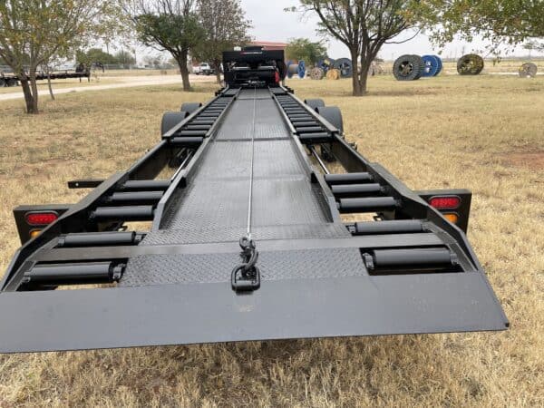 A large trailer is parked in the grass.