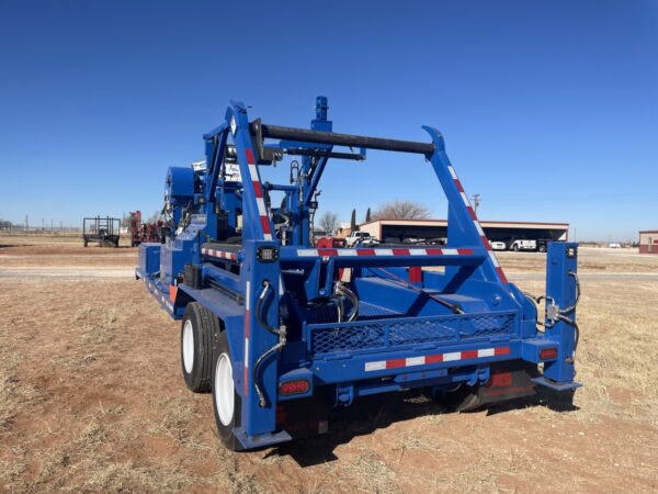 A blue truck is parked in the dirt.