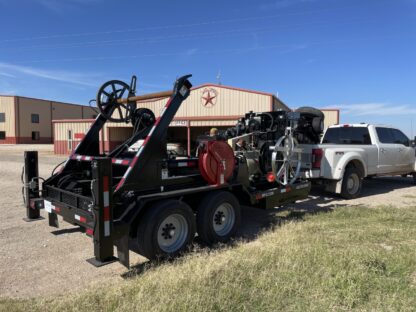 A tow truck is parked next to the side of a building.