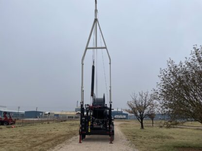 A large black truck parked on top of a dirt road.