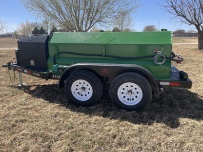 A green trailer with two tires and a black tank.