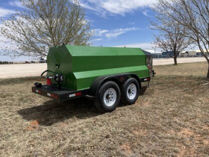 A green trailer with trees in the background