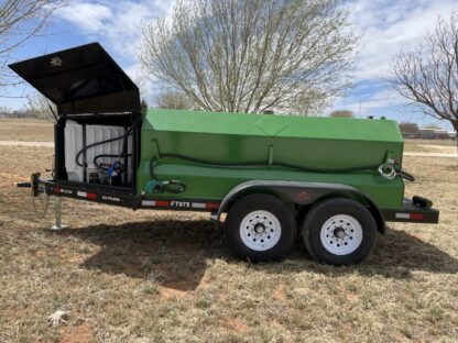 A green trailer with a black tarp on the back.