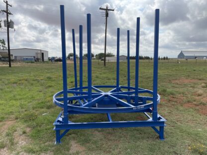 A blue metal structure in the middle of a field.