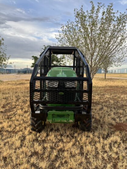 A green and black utility vehicle parked in the grass.