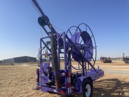 Purple industrial machine on a trailer outdoors.