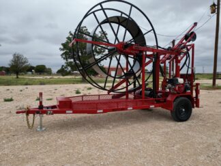 Red cable trailer on gravel lot.