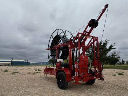 Red industrial cable spool trailer outdoors.